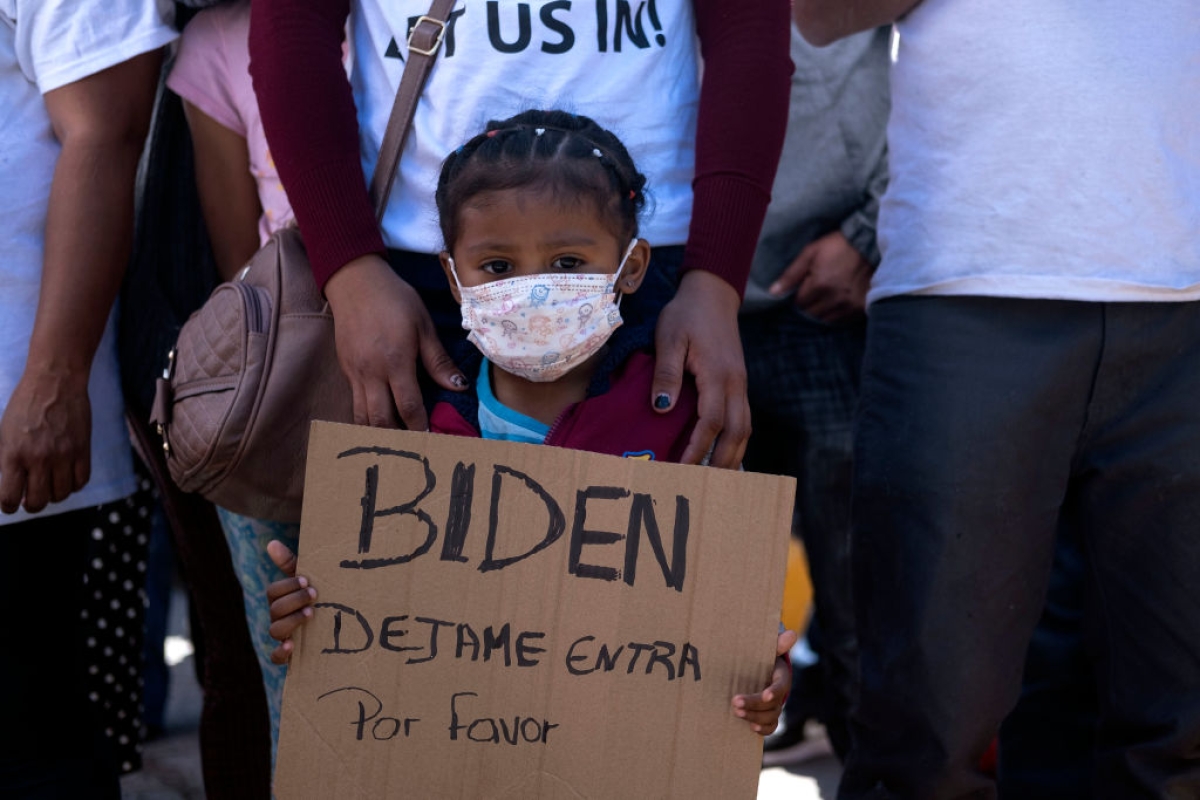 Dareli Matamoros, a girl from Honduras, holds a sign asking President Biden to let her in during a migrant demonstration demanding clearer United States migration policies, at San Ysidro crossing port in Tijuana, Baja California state, Mexico on March 2, 2021. (Getty)