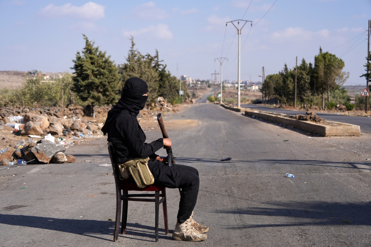 A member of the Internal Security Forces stands watch at a checkpoint in the village of Al-Mazra'a, after days of violence in Suweida between Bedouin fighters and Druze factions, on 20 July 2025.