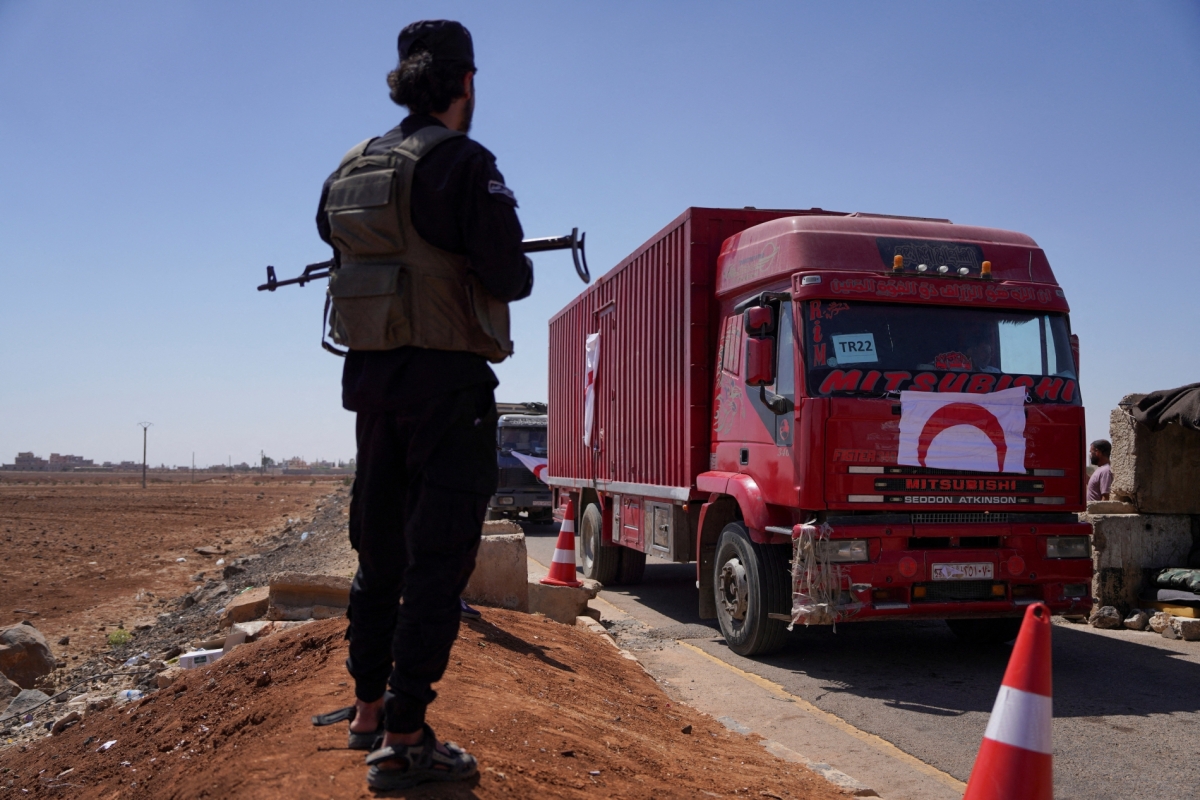A member of Syrian security forces stands near a vehicle carrying aid as they make their way to Suweida, at Bosra al-Sham town, near Deraa, Syria July 23, 2025.