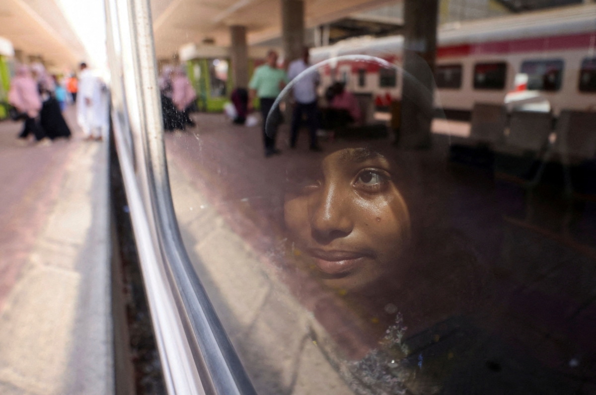 A child looks outside from a train window as Sudanese families displaced by conflict return home voluntarily from Egypt to Sudan, on a special train, Cairo July 21, 2025.