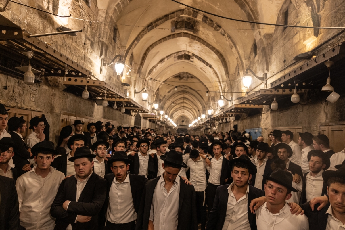 Ultra-Orthodox Jewish men stand at one of the gates to the Haram Al Sharif during the annual Tisha B'Av commemorating the destruction of ancient Jewish temples some 2,000 years ago.