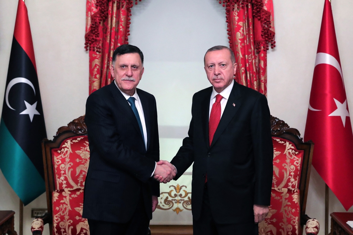 Turkish President Recep Tayyip Erdogan shakes hands with Fayez al-Sarraj, the head of the Tripoli-based Government of National Accord, in Istanbul after signing a military deal on November 27, 2019.