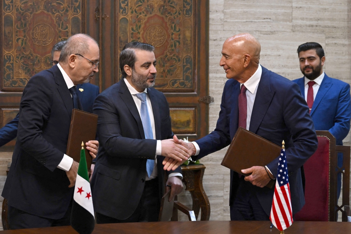 Jordanian Foreign Minister Ayman Safadi (left) watches as Syrian Foreign Minister Asaad al-Shaibani (center) greets US Special Envoy to Syria Tom Barrack after signing an agreement in Damascus on September 16, 2025.