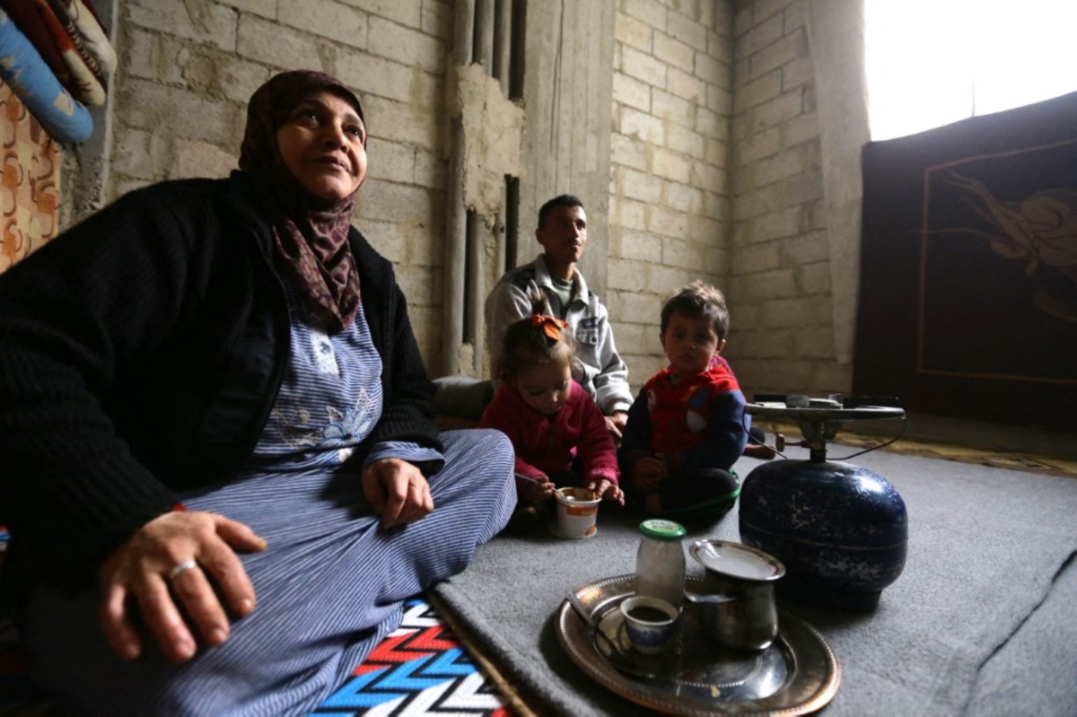 Umm Walid sits near her grandchildren in a room of an unfinished building where she lives with her five children and their families in the Daf al-Sakhr neighbourhood of Jaramana on the outskirts of the Syrian capital Damascus.