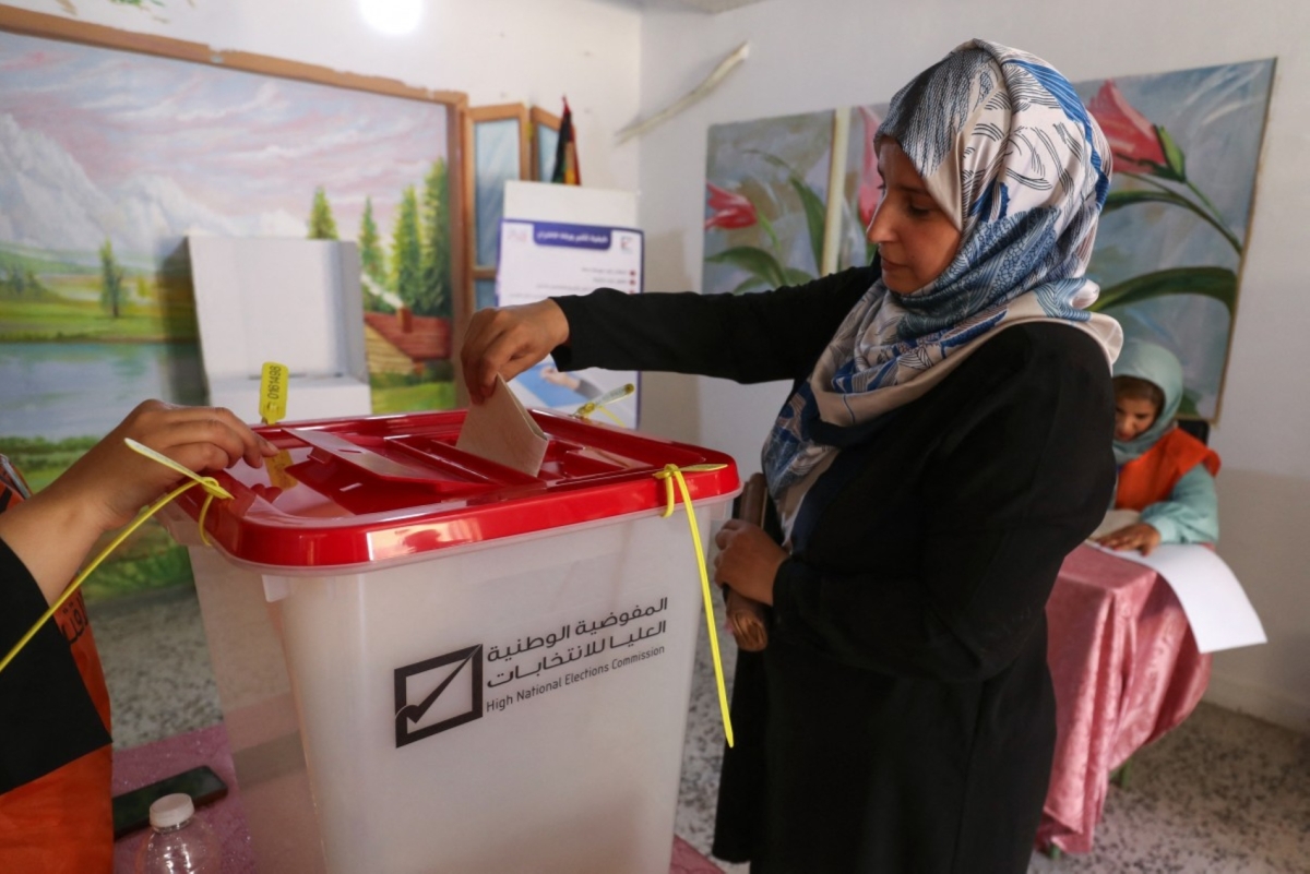 A Libyan voter casts her ballot for municipal elections at a polling station in Tripoli on August 16, 2025. 