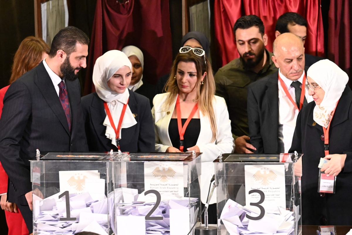 Syrian President Ahmed al-Sharaa (L) visits the polling station where members of Syrian local committees have been casting their votes to select members of an interim parliament, in Damascus on October 5, 2025.
