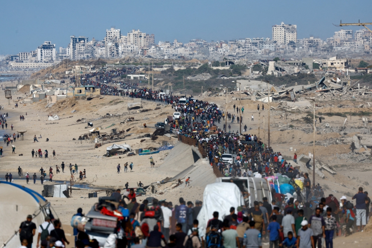 Palestinians, who were displaced to the southern part of Gaza at Israel&#039;s order during the war, make their way along a road as they return to the north after a ceasefire went into effect on October 10, 2025.