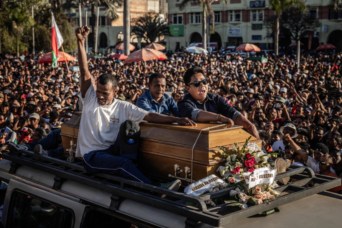Family members of a protester killed during clashes carry the casket atop a van as protesters gather around during a civil society rally demanding the resignation of President Andry Rajoelina in Antananarivo, on October 13, 2025.