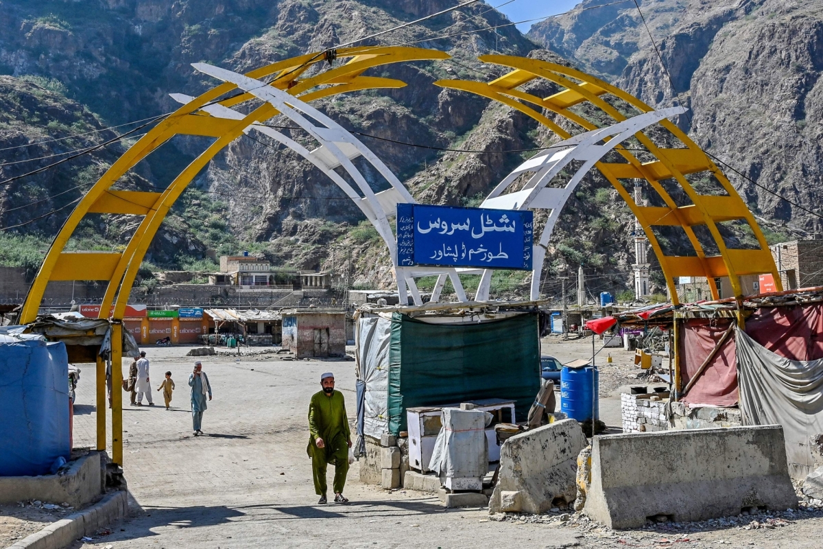A man walks across a bus stand at the Pakistan-Afghanistan border town of Torkham on October 13, 2025, amid cross-border clashes between the two countries. 