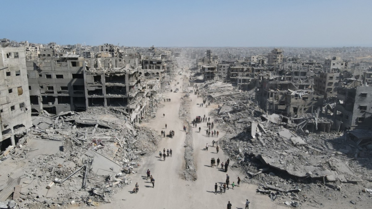 People walk amid the destruction in Gaza City in the northern Gaza Strip on October 11, 2025, a day after a ceasefire took effect.