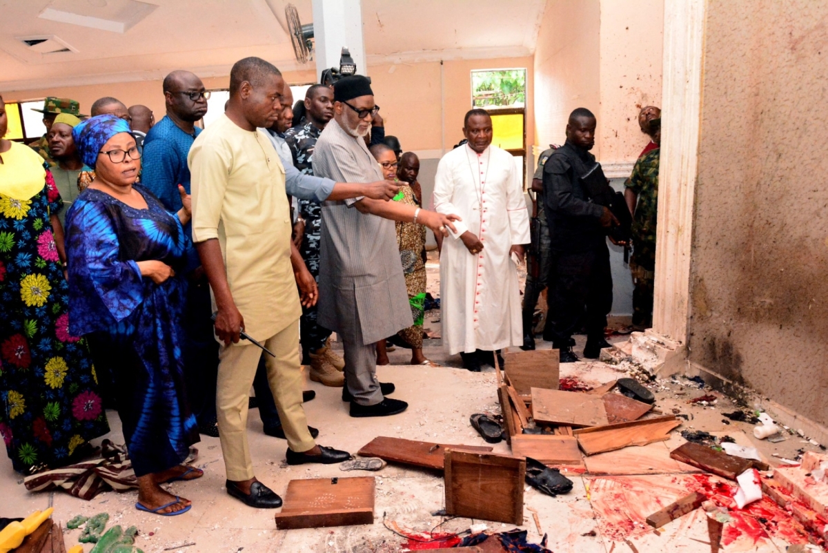 Ondo State governor Rotimi Akeredolu (3rd L) points to blood the stained floor after an attack by gunmen at St. Francis Catholic Church in Owo town, southwest Nigeria on 5 June 2022.