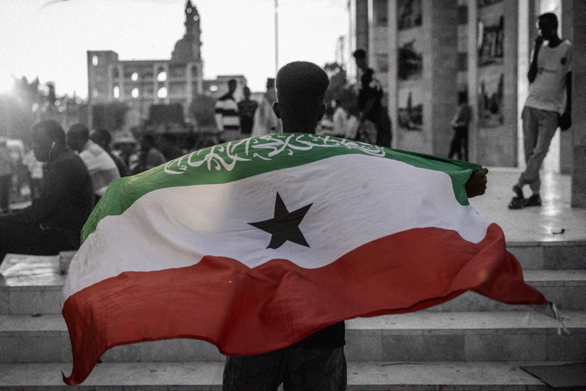 A man holding the flag of Somaliland in front of the Hargeisa War Memorial, on 7 November 2024.
 