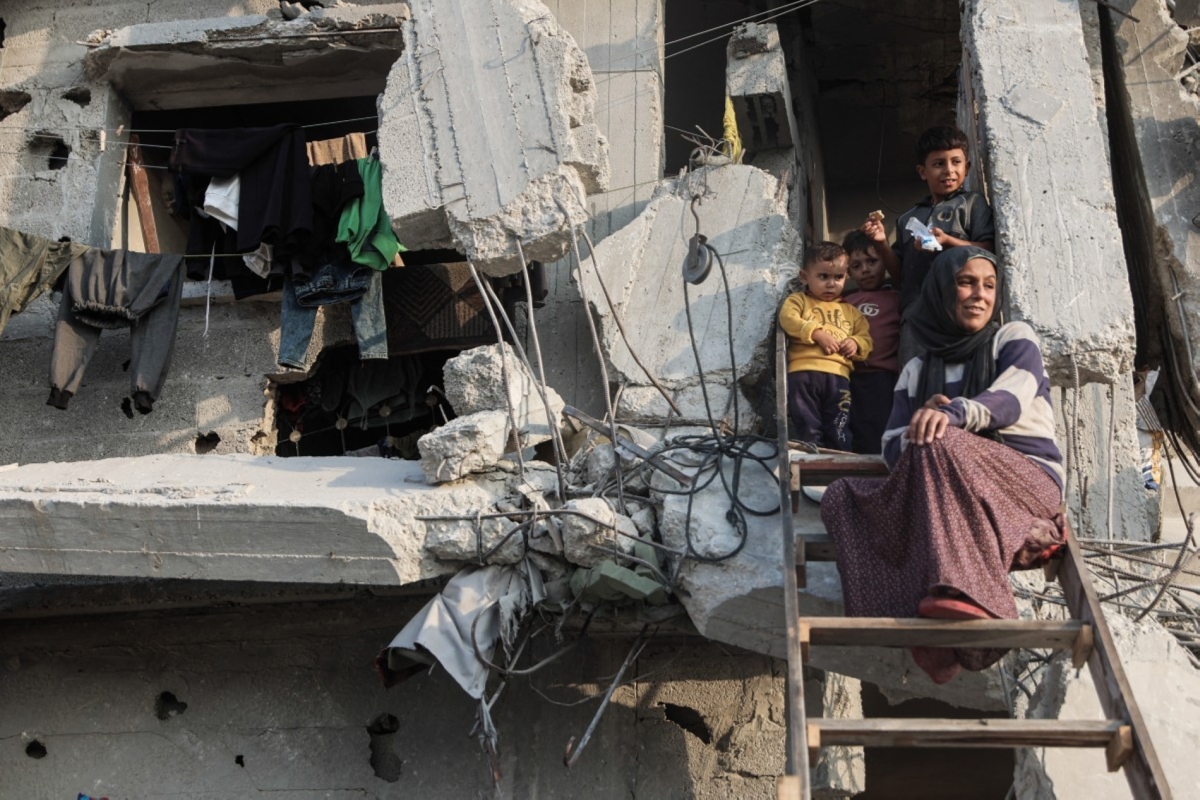 A Palestinian family looks down from their heavily damaged home in Jabalia, in the northern Gaza Strip, on 7 November 2025.