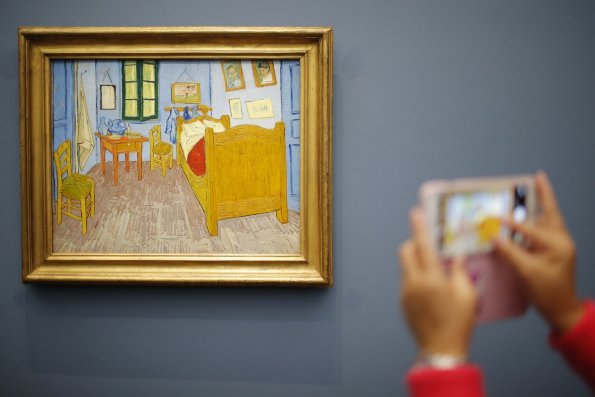 A visitor takes a picture of the painting La Chambre de Van Gogh a Arles, 1888 (Van Gogh's Bedroom in Arles) at the Musee d'Orsay in Paris, France.