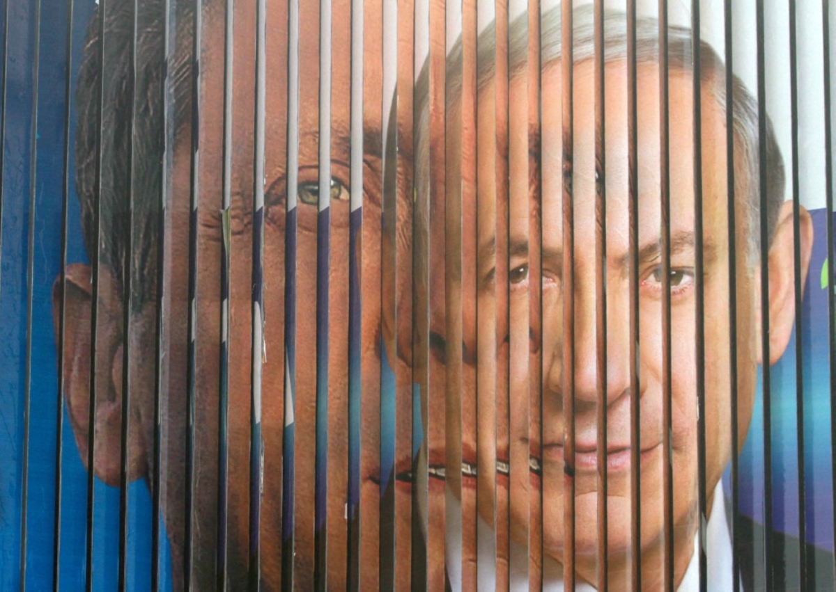 A giant campaign billboard rotates showing Likud candidate Benjamin Netanyahu (R) and Labour Party leader Isaac Herzog (L) in March 2015. Today, Netanyahu is asking Herzog to grant him a presidential pardon.