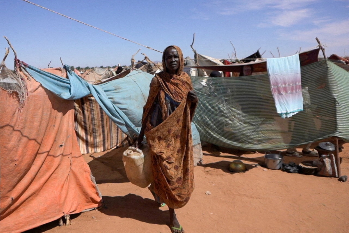 A displaced Sudanese woman who was held by the Rapid Support Forces (RSF) carries a water container at a camp for displaced people who fled from El-Fasher to Tawila, North Darfur, Sudan, on 15 November 2025. 