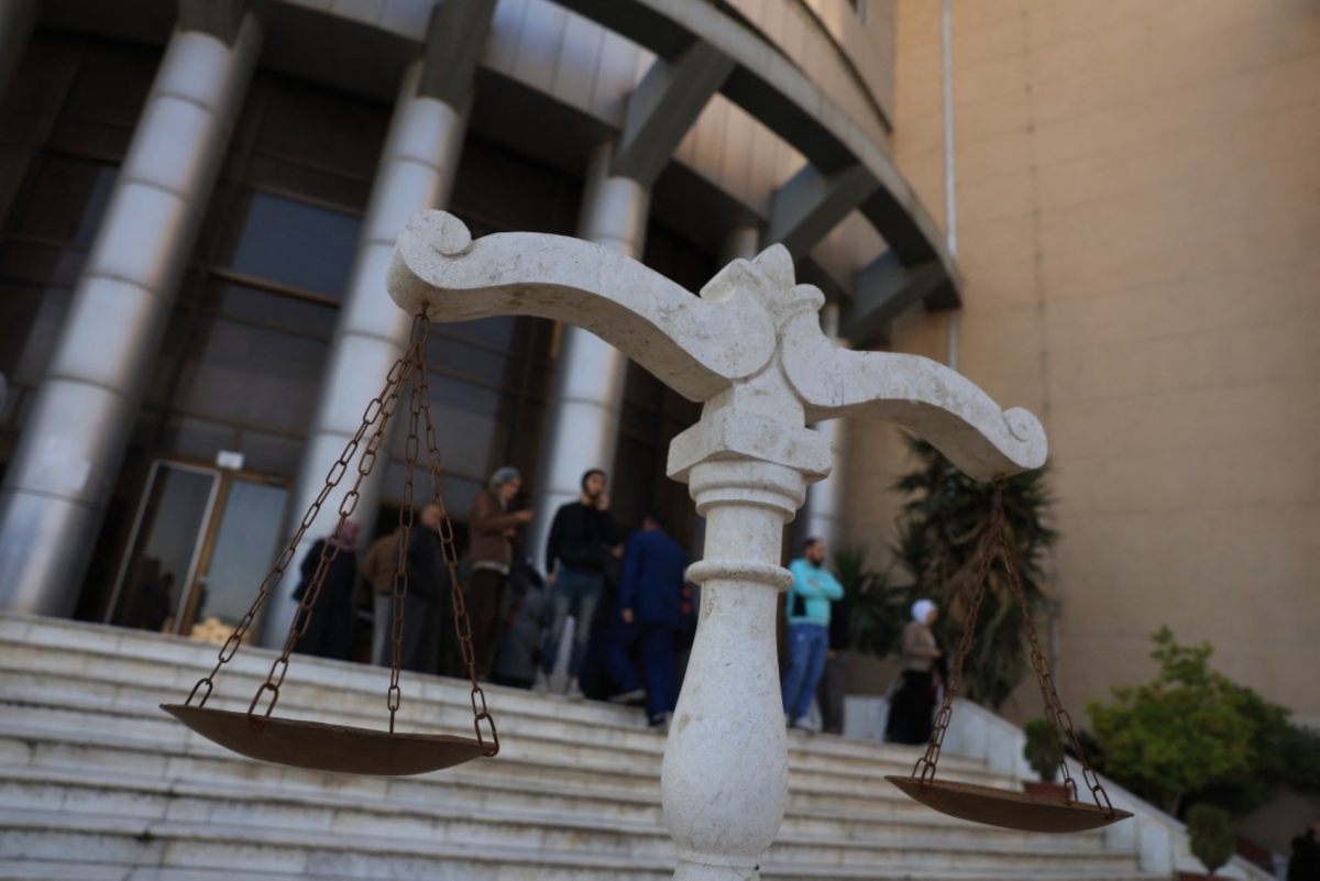 People stand outside the Justice Palace after first trial of more than a dozen suspects linked to massacres that left hundreds dead in Syria's Alawite coastal heartland earlier this year, in Aleppo on 18 November 2025.