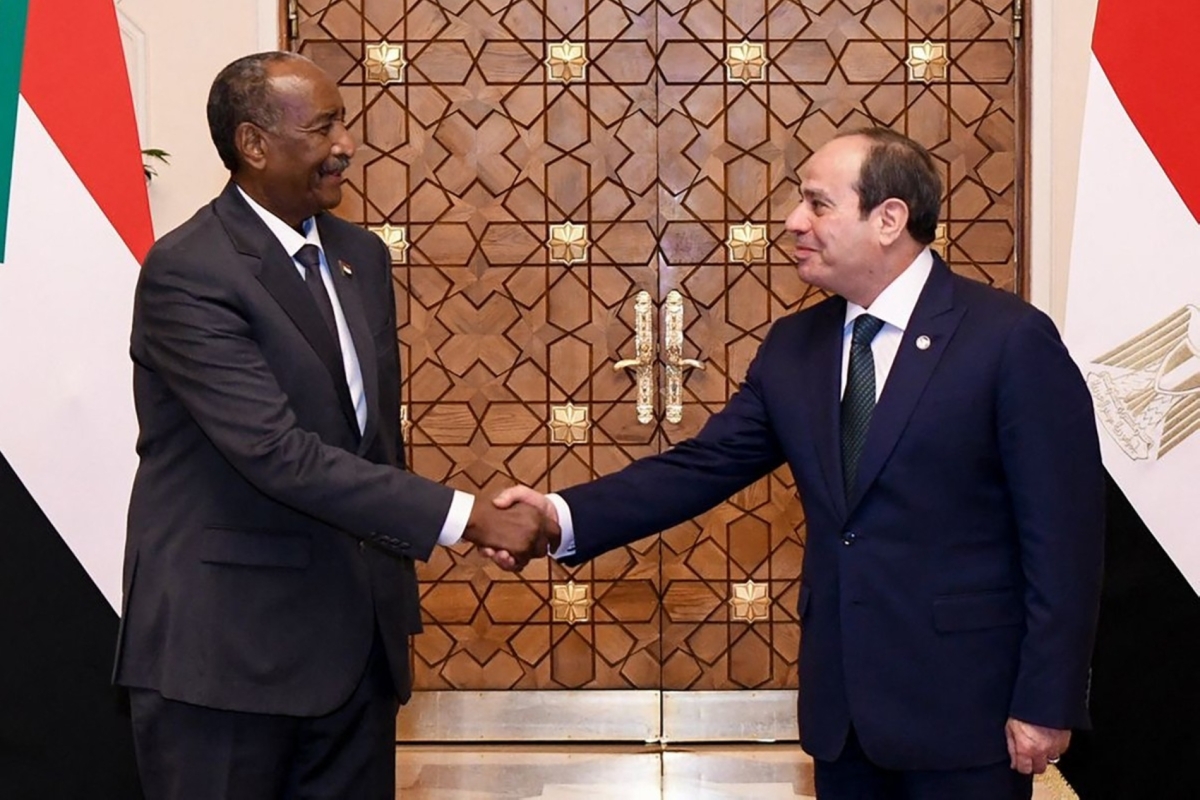 Egyptian President Abdel Fattah al-Sisi (R) shakes hands with Sudan's army chief General Abdel Fattah al-Burhan in Cairo on 18 December 2025.
