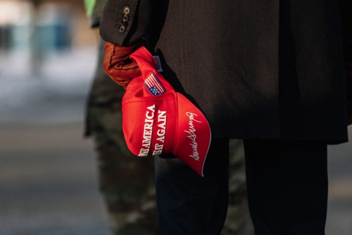 Trump holding a Make America Great Again Hat 
