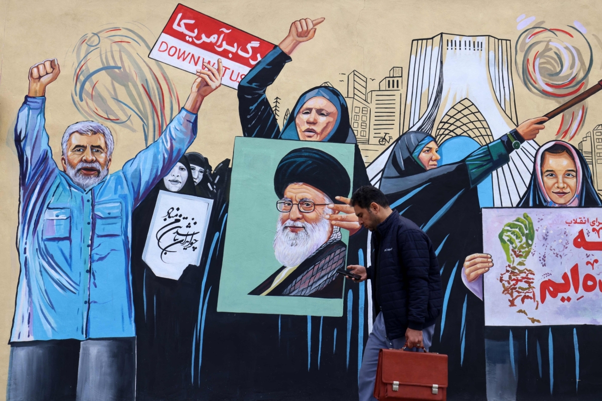 A man walks past an anti-USA and anti-Israel mural in Tehran on 8 April 2026.