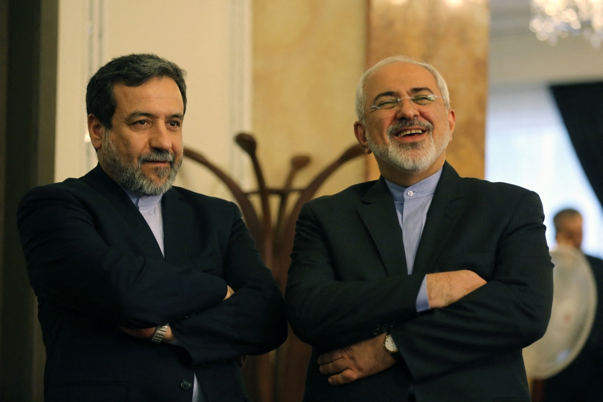 Iranian Foreign Minister Javad Zarif (R) and Deputy Foreign Minister and chief nuclear negotiator Abbas Araghchi react as they listen to President Hassan Rouhani (unseen) speaking during a press conference in Tehran on 3 April 2015