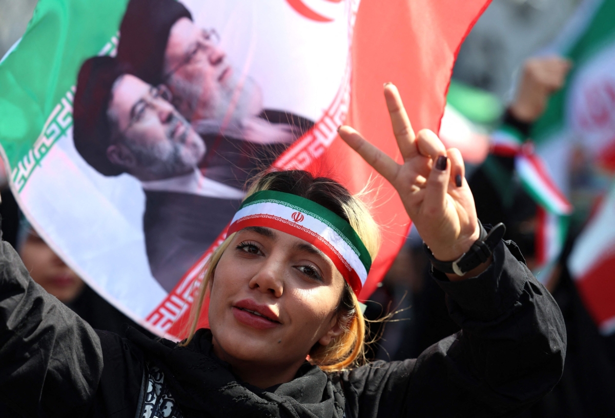 An Iranian woman flashes the V-sign as she takes part in a rally to pay tribute to women killed during war, in Tehran on 17 April 2026.