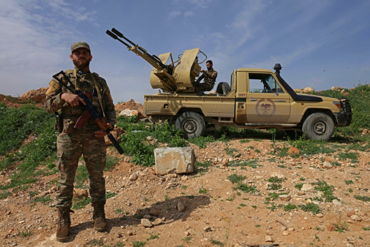 A Syrian army soldier stands guard next to an armoured vehicle positioned along the Syrian–Lebanese border in the rural area of Al Qusayr on 1 April 2026.