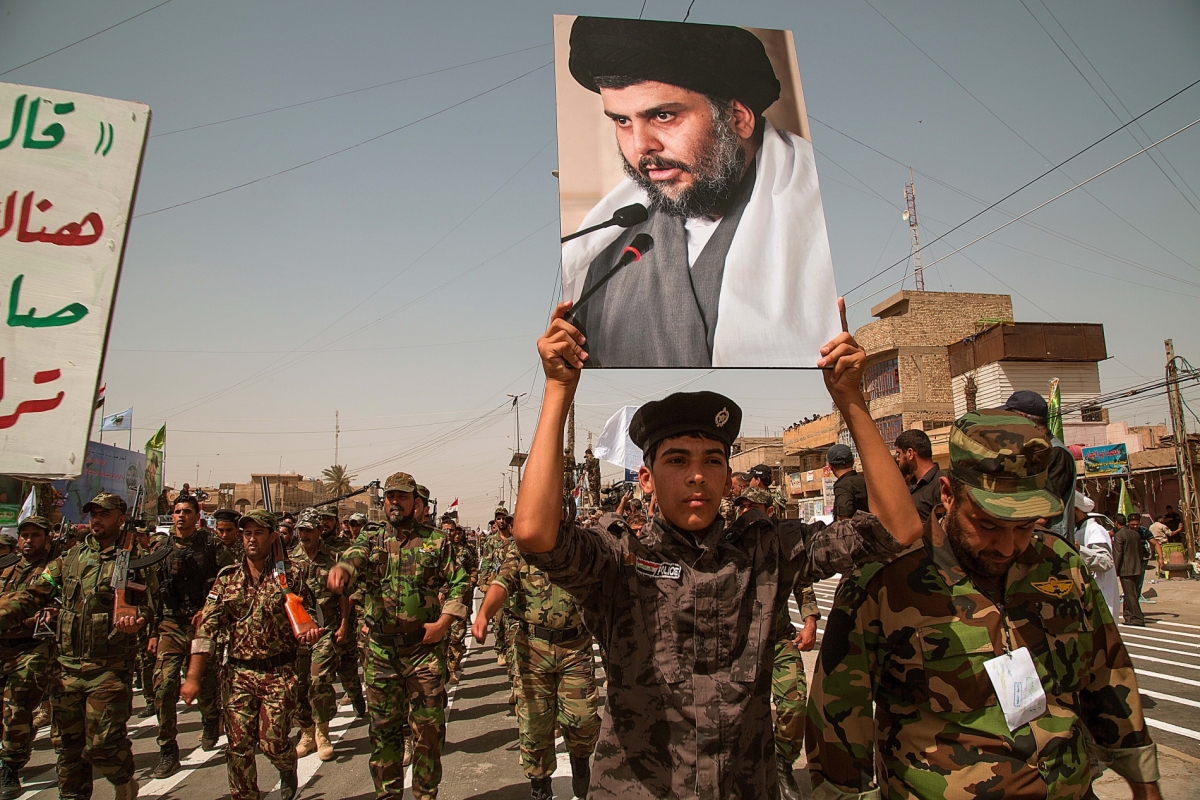 Units of Moqtada Sadr's militia parade with his photo down a main street of the Shiite stronghold of Sadr City June 21, 2014, in Eastern Baghdad.