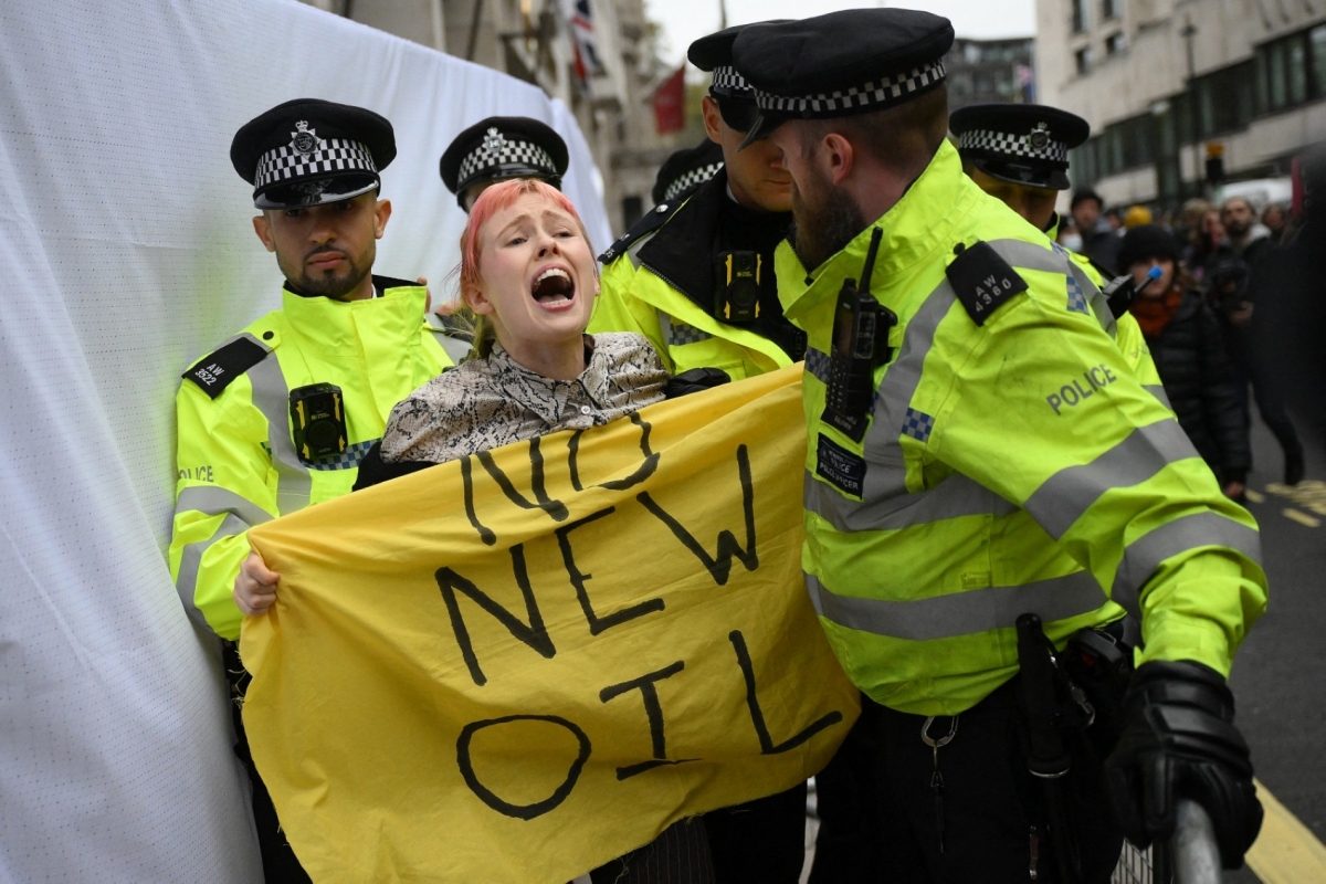 Police officers remove a climate activist protesting against the Rosebank oil field project in the North Sea off the coast of Scotland in central London on 18 October 2023. 