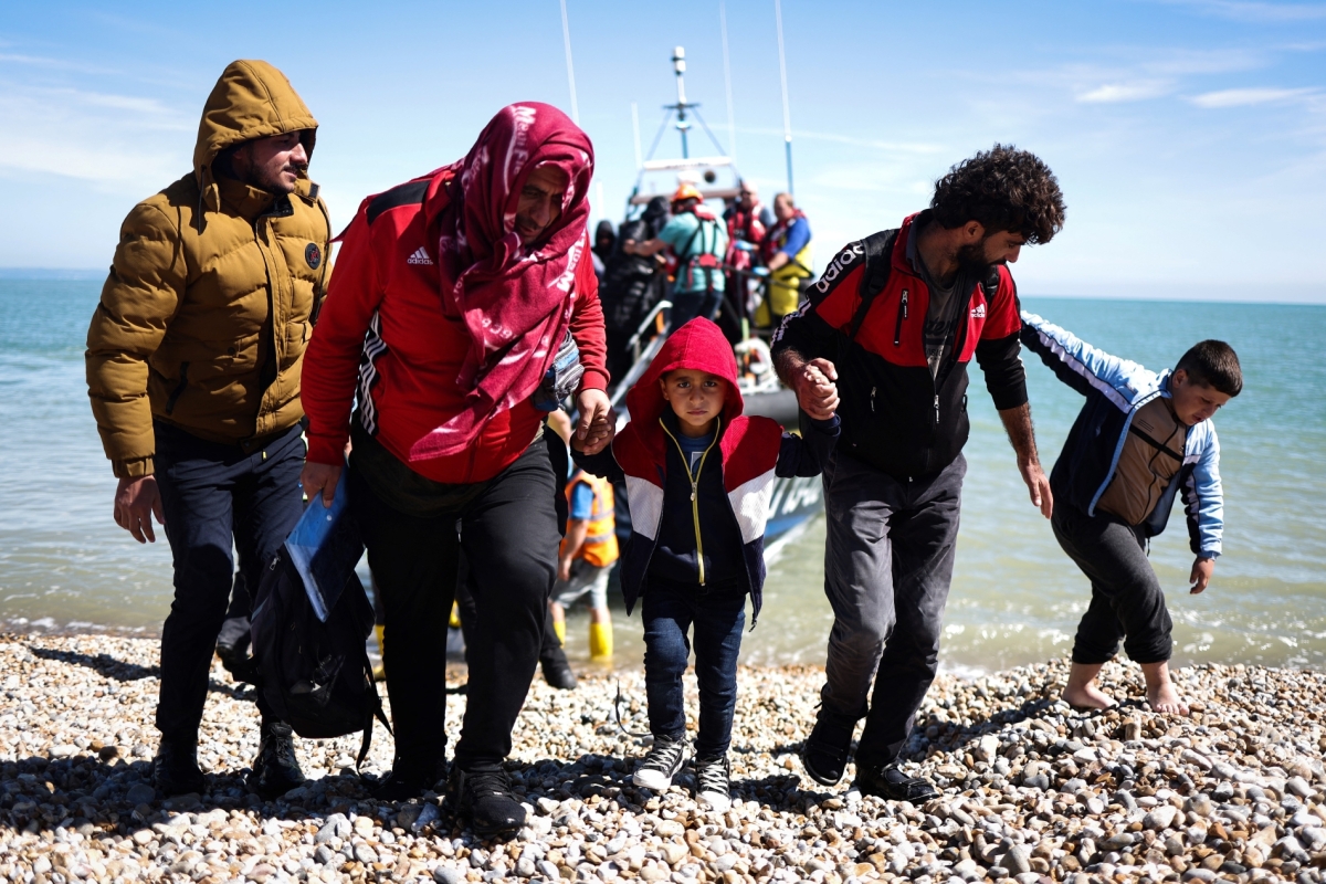 Migrants disembark from a lifeboat on the southeast coast of England after being picked up at sea while crossing the English Channel from France on 16 August 2023.