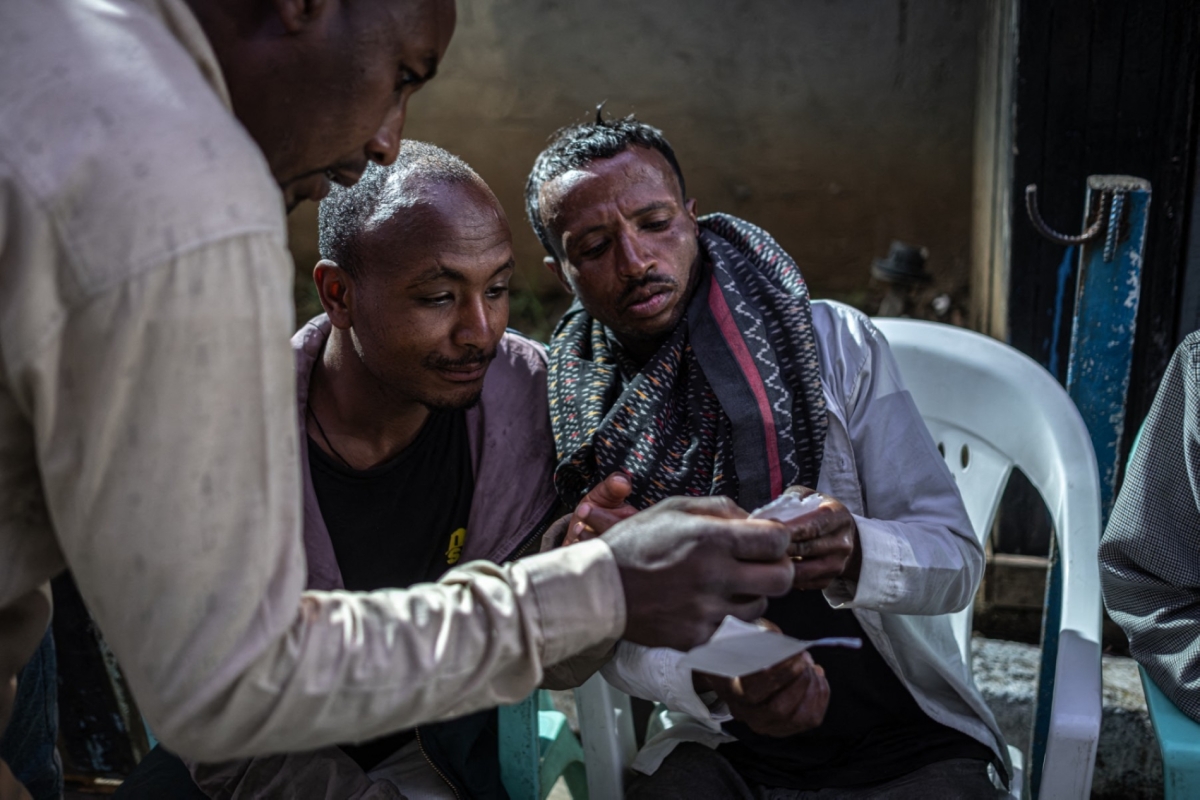 MARCO SIMONCELLI / AFP
Photo by MARCO SIMONCELLI / AFP
Voters check their voter registration cards outside Shalla Park polling station in Addis Ababa on 1 June 2026, during the 2026 Ethiopian parliamentary elections.