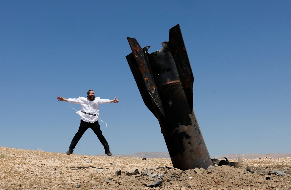 An Israeli Ultra-Orthodox Jew reacts near a part of a missile protruding from the ground, following strikes from Iran, in the central Israeli-occupied West Bank, on 8 June 2026.
