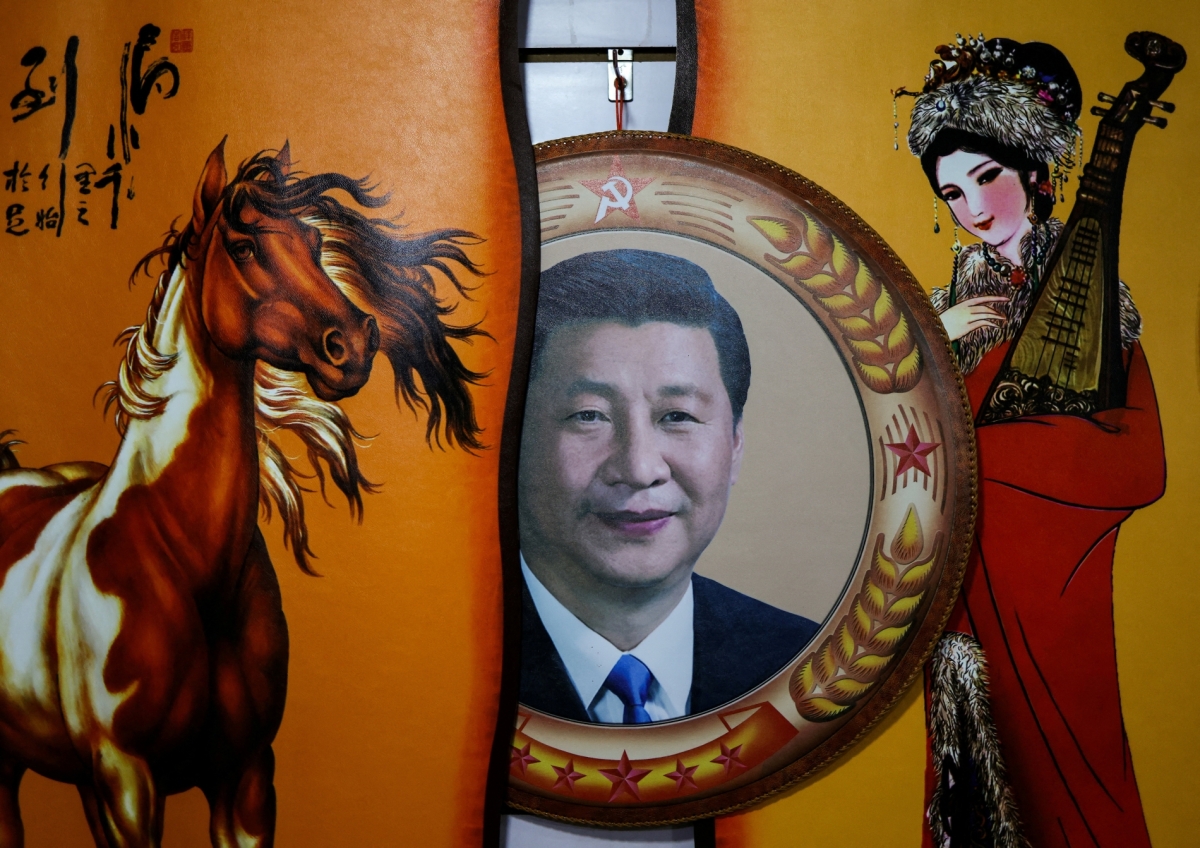 A portrait of Chinese President Xi Jinping next to traditional paintings in a tourist store in Hohhot, Inner Mongolia.