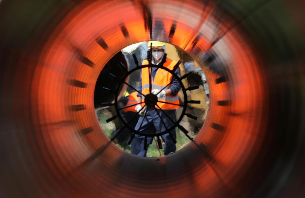 Workers are seen through a pipe at a construction site on the extension of Russia's TurkStream gas pipeline.