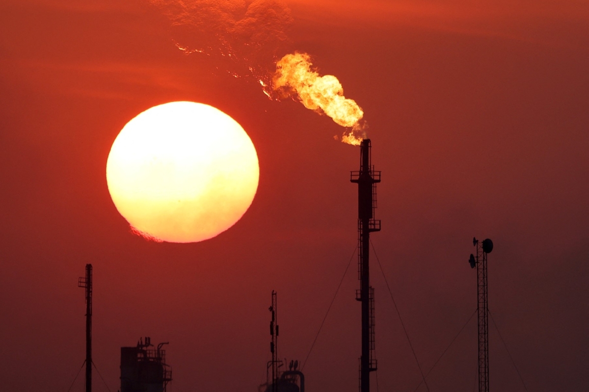 The sun sets behind burning gas flares at the Daura Oil Refinery Complex in Baghdad, 22 December 2024