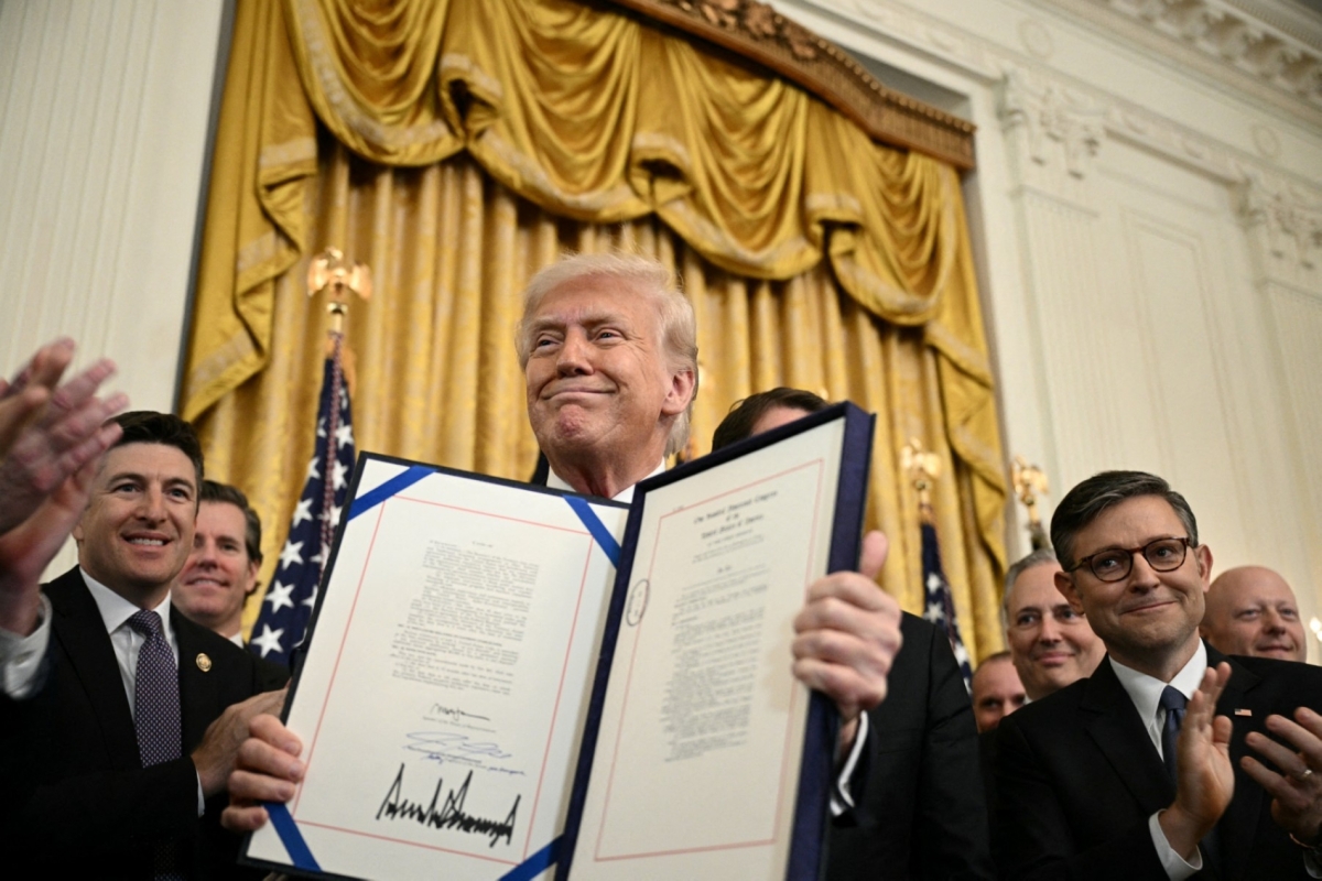 US President Donald Trump displays the GENIUS Act (Guiding and Establishing National Innovation for US Stablecoins Act) after signing it in the East Room of the White House in Washington, DC, on 18 July 2025. 