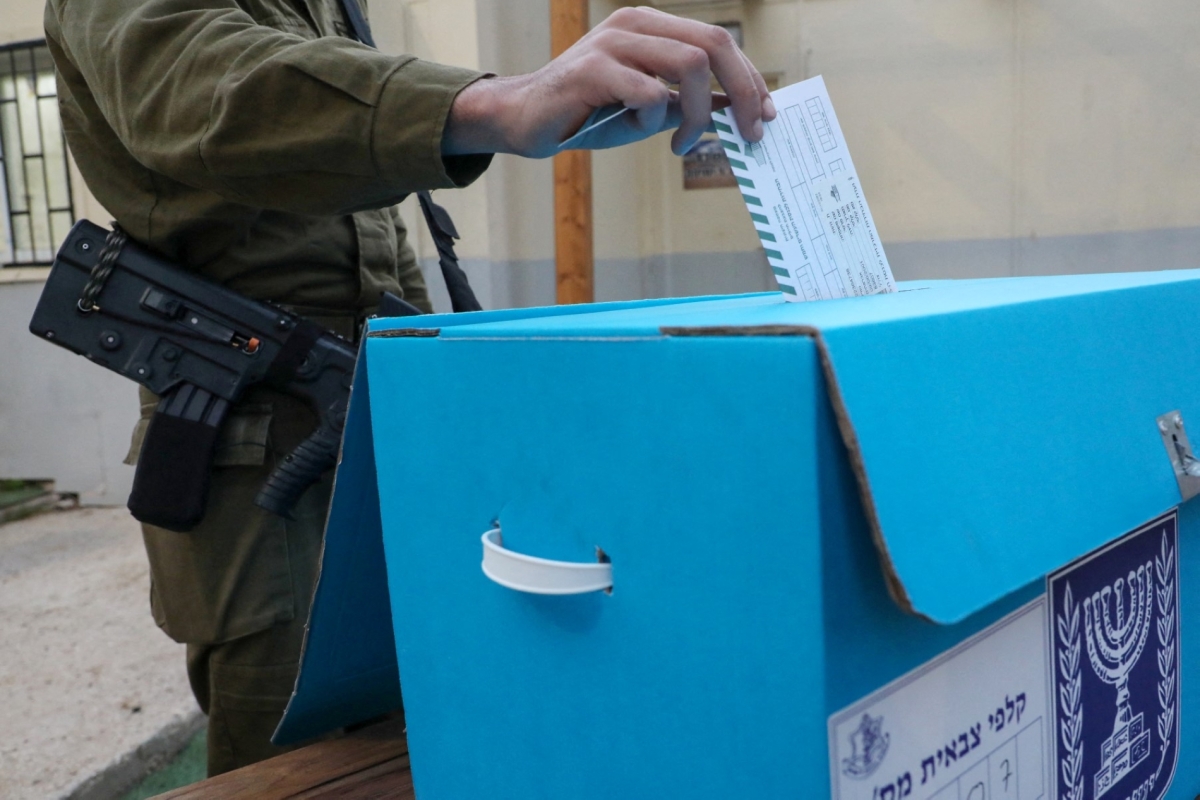 An Israeli soldier casts his vote a day before the Israeli general election at a military base in southern Israel, near the border with the Gaza Strip, on 31 October 2022.