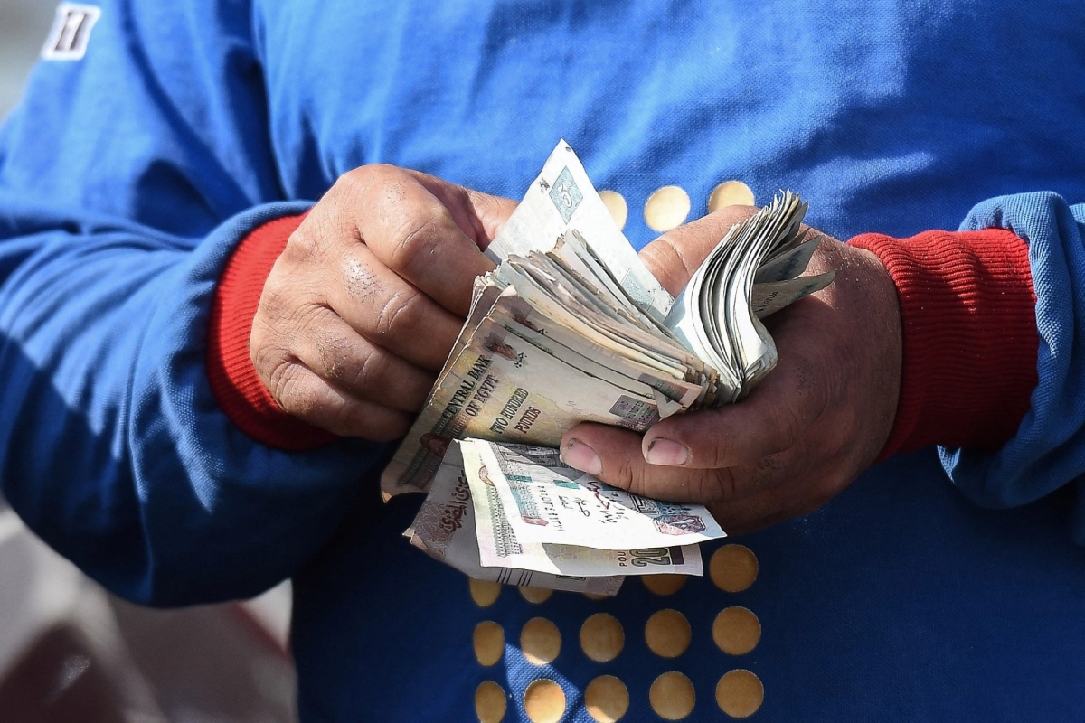 A worker counts money at a petrol station in Cairo on 26 July 2024, as Egypt’s government announced yesterday a new increase in fuel prices.