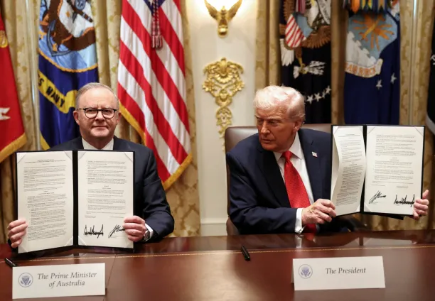 US President Donald Trump and Australia's Prime Minister Anthony Albanese hold a signed agreement on rare earths and critical minerals during a meeting in the Cabinet Room at the White House in Washington, DC, on October 20, 2025.