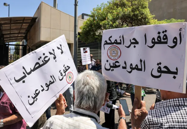 متظاهرون يرفعون لفتات تندد باختلاس أموال الموديعين، 23 يوليو 2023