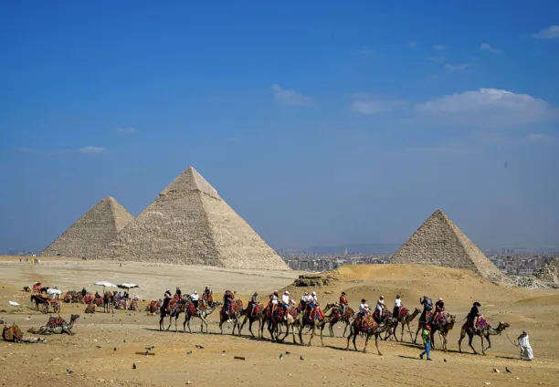 سياح يركبون الجمال أثناء جولة حول الأهرام، الجيزة 7 نوفمبر 2025
