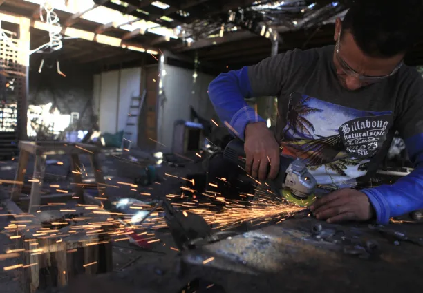 حداد يعمل في ورشة للحدادة بقرية فجنون للفنون في الجيزة، مصر، 30 يناير/كانون الثاني 2014