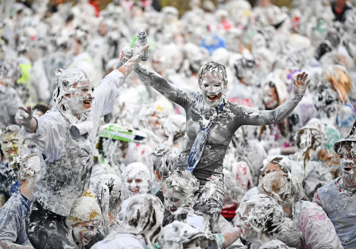 Students from St Andrews University, many in fancy dress, indulge in a tradition of covering themselves with foam to honour the 'academic family' on the lower college lawn on October 22, 2018, in St Andrews, Scotland. (Getty)