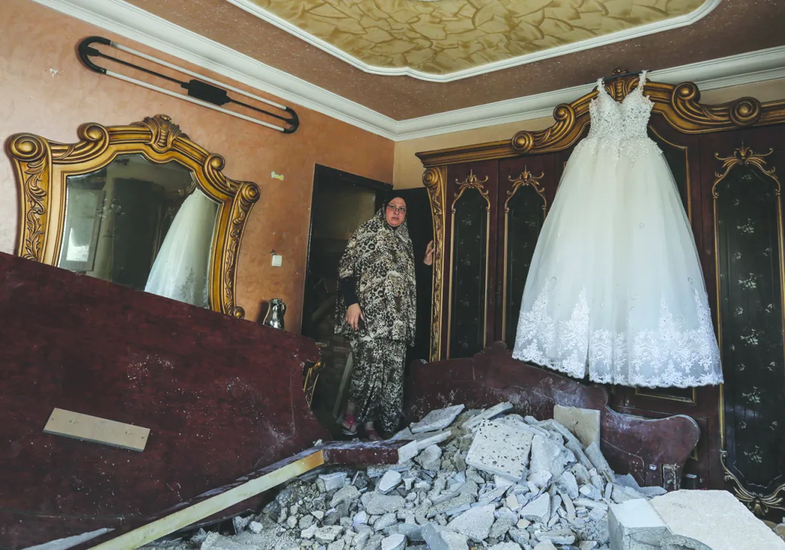 A Palestinian woman walks into a room damaged by an Israeli airstrike earlier this week, in the Gaza Strip on November 14, 2018. (Getty)
