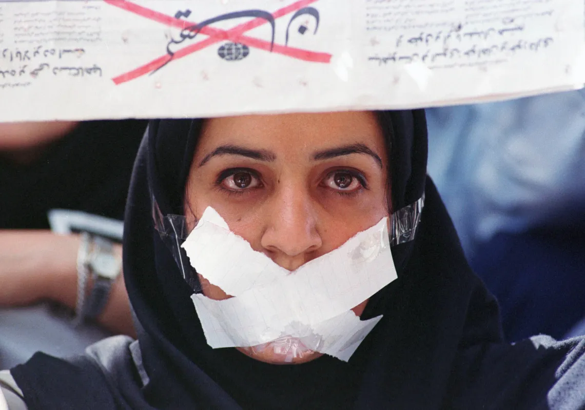A female student demonstrates against censorship at Tehran university, after reformist newspapers were closed down. She holds a copy of the newspaper 'Kayhan', known for its extremist pro-regime ideas, upside down.