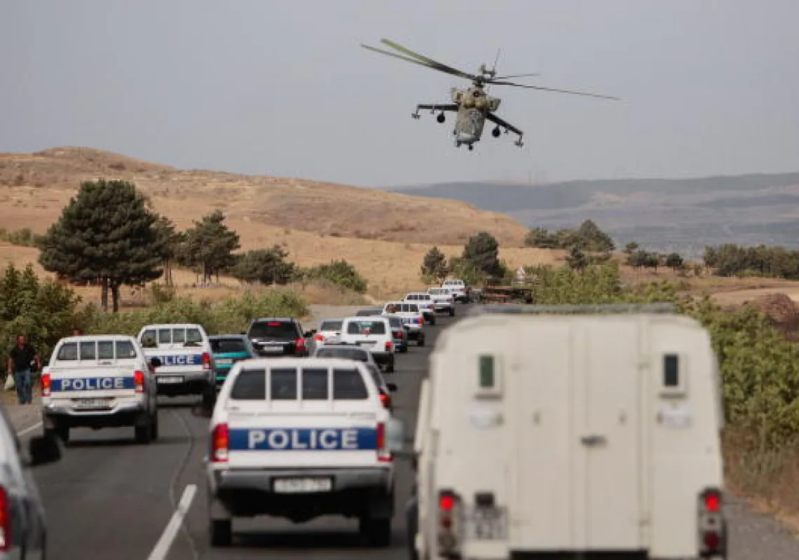-	مروحية روسية تحلق فوق قافلة تضم قوات من الشرطة الجورجية وصحافيين دوليين في 14 أغسطس عام 2008 على أطراف مدينة غوري بجورجيا. (غيتي)