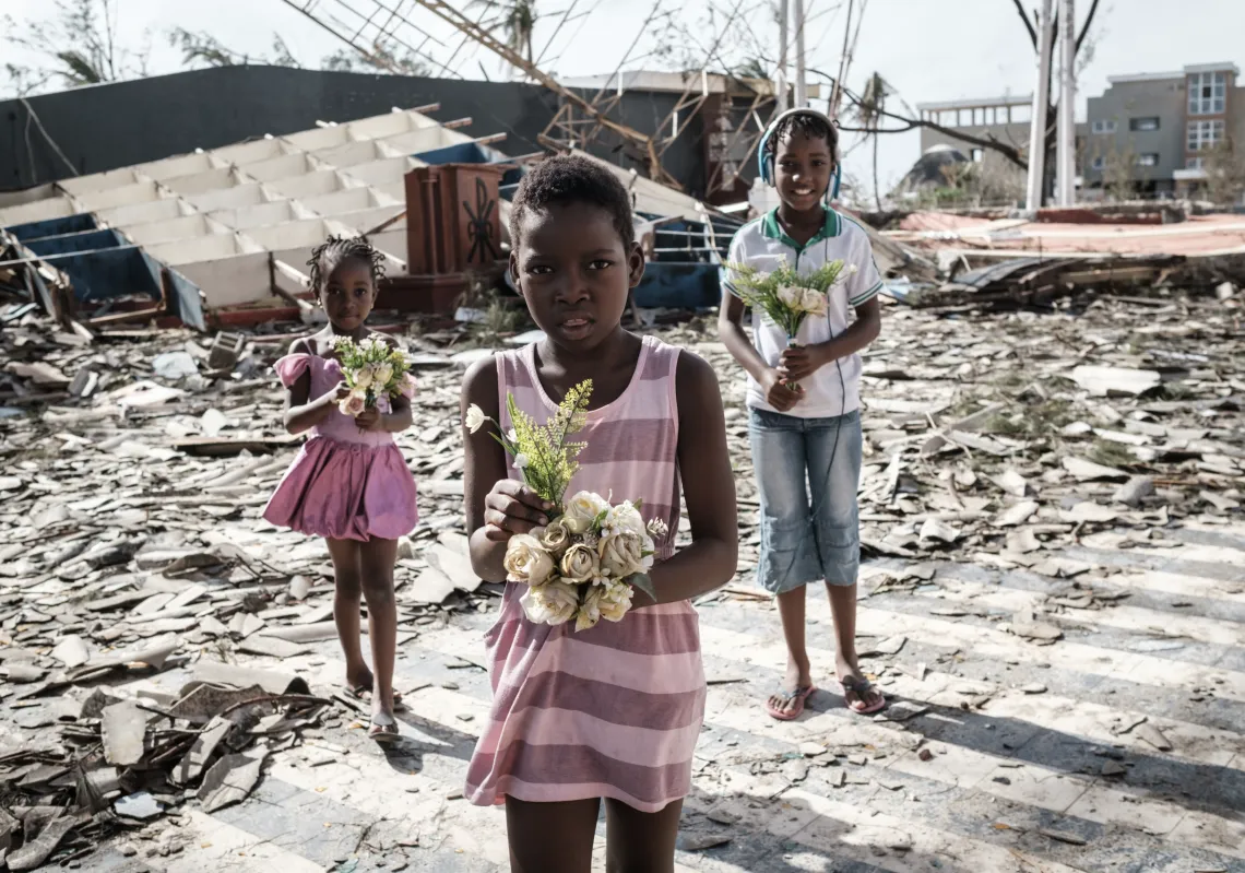 Girls collect artificial flowers from the rubble of a building destroyed by the cyclone Idai at Sacred Heart Catholic Church in Beira, Mozambique, on March 24, 2019. (Getty)