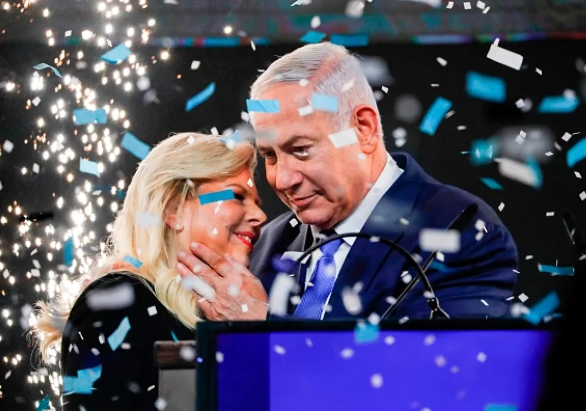رئيس الوزراء الإسرائيلي بنيامين نتنياهو و زوجته سارا يحتفلان بفوزه بولاية خامسة بينما يتم تفجير الألعاب النارية أثناء ظهوره أمام مؤيدي حزب الليكود في مدينة تل أبيب الساحلية في ليلة الانتخابات في وقت مبكر يوم 10 أبريل 2019. (أ ف ب) 