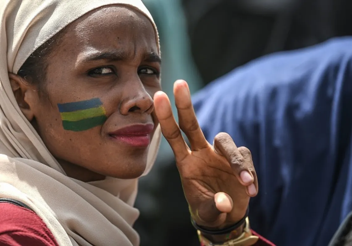 محتجة سودانية ترفع علامة النصر خلال تجمع حاشد خارج مقر الجيش في العاصمة السودانية الخرطوم في 18 أبريل 2019. (غيتي)