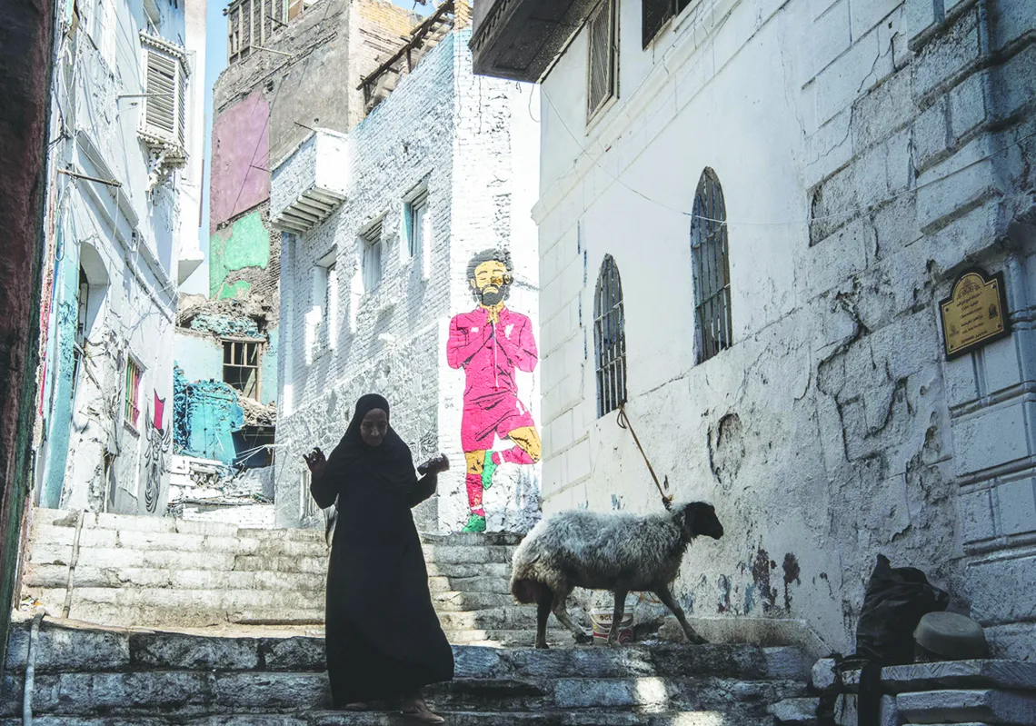 An Egyptian woman walks past a mural of Egyptian footballer Mohamed Salah in Cairo on June 17, 2019, four days ahead of the African Cup of Nations debut (CAN) (Getty)